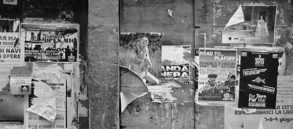 Auf dem Bild ist eine Wand mit vielen Plakaten zu sehen.